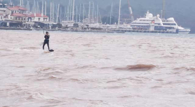 Yağışa aldırmadan denizde sörf yaptı