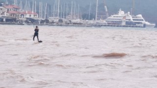 Yağışa aldırmadan denizde sörf yaptı